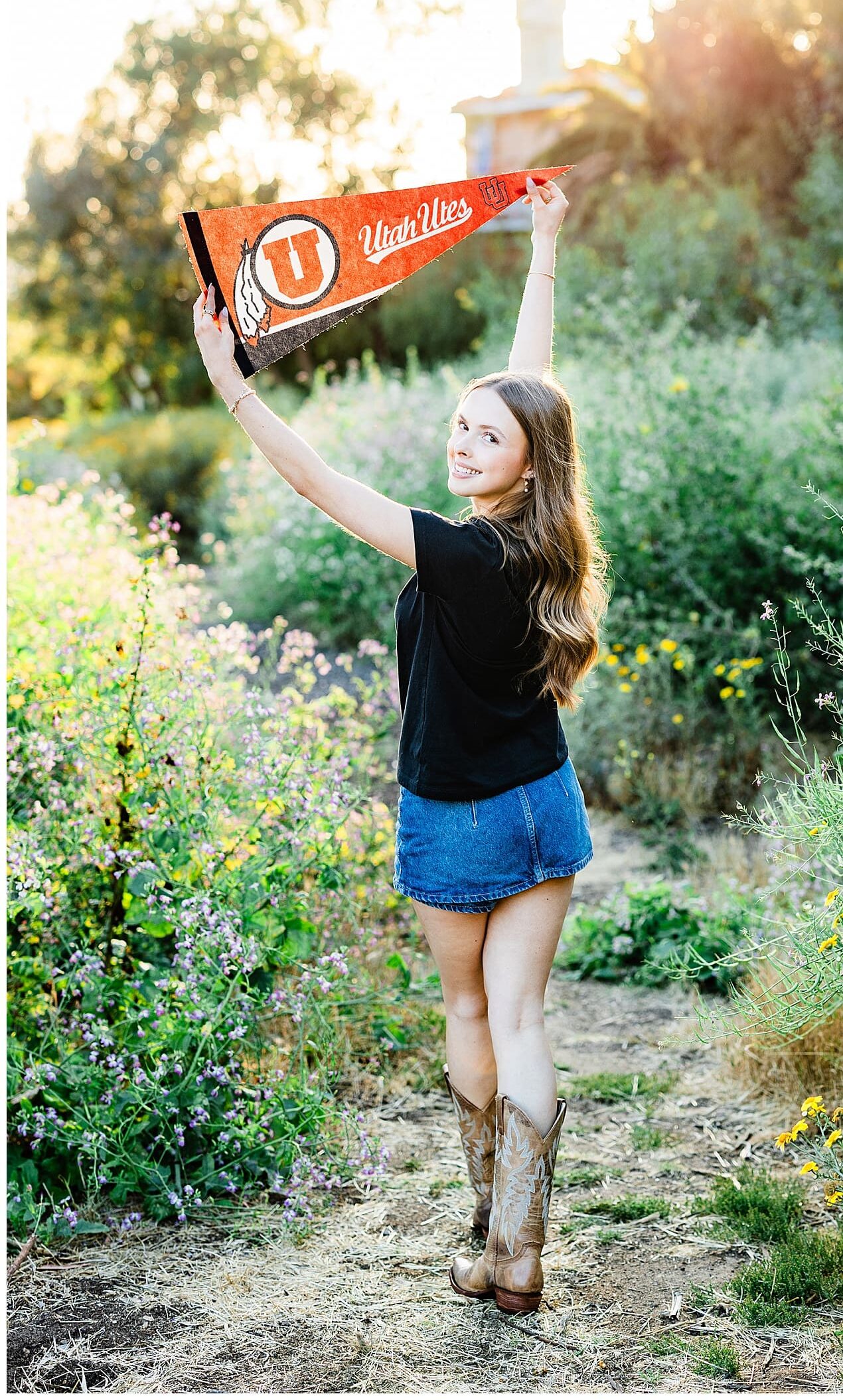 A high school grad holding the pennant for her future college.
